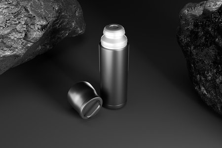 Mockup of a black metal bottle on a dark background with rocks 3d renderingの写真素材