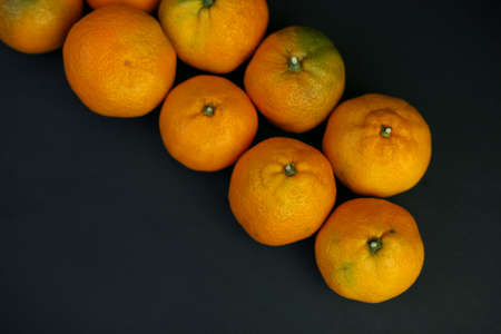 tangerines on a black background. healthy food concept, eco-friendly natural products, vegetarian, raw, organic, Tropical abstract backgroundの写真素材