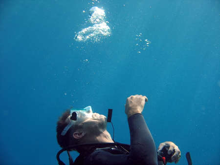 A diver blowing bubbles in the water.の写真素材