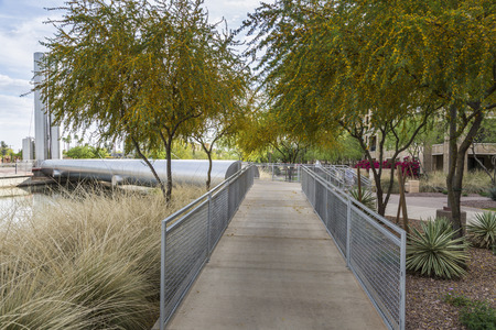 Pedestrian ramp and blooming mesquite trees at the Soleri Bridge in Scottsdale Arizona.の写真素材