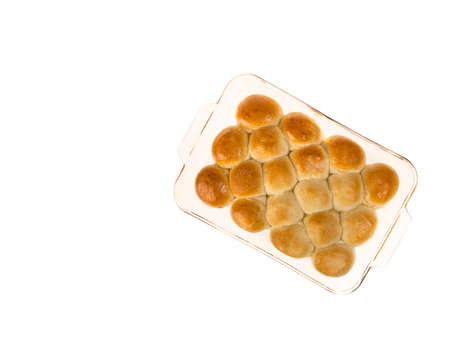 Pan of hot dinner rolls fresh from the oven in a glass pan isolated on white with copyspace.の写真素材