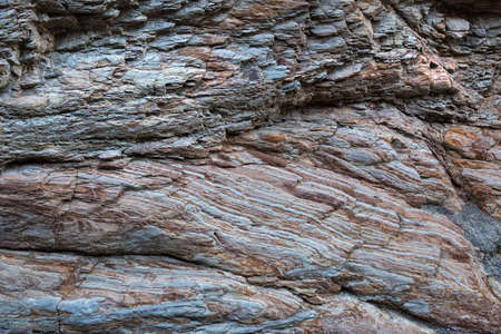 Canyon wall in Mosiac Canyon at Death Valley California showing a smooth eroded mosaic surface with many mineral layers folded and deformed by pressure.の写真素材