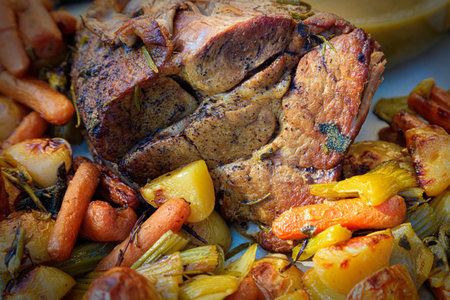 Juicy herbed pork roast with potatoes, carrots, onions and celery.の写真素材