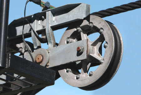 A large cable pulley system used to run a ski lift. Set against a clear blue sky.の写真素材