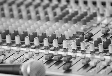 A sound mixing board and microphone. Selective foxud on the center knobsの写真素材