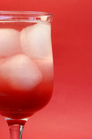 A delicious red cocktail drink on ice. Served in a tall stem daiquiri glassの写真素材