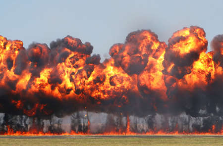 Giant Explosion! A wall of fire explodes on an open field. の写真素材