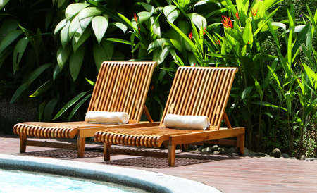 Resort lounge chairs surround an elegant poolの写真素材