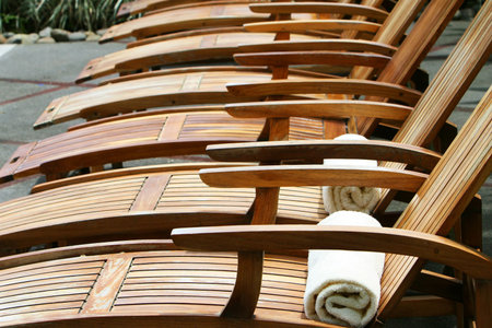 Wooden lounge chairs awaiting pool guests