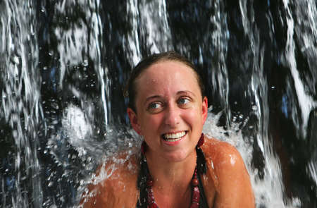 A young woman under a waterfall at a five star spa in Costa Ricaの写真素材