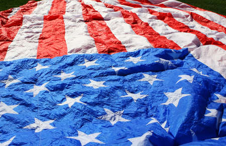 A giant american flag lying on the grassの写真素材