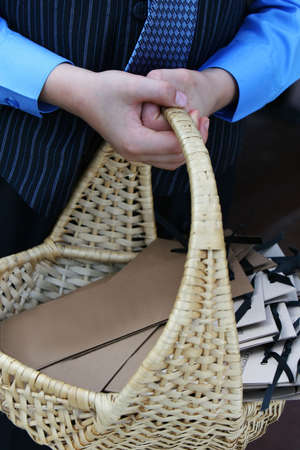 Basket of blank programs for a  ceremony, held my a young man in formal attireの写真素材