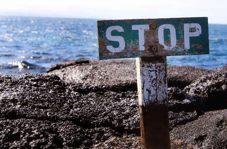 This stop sign warns visitors to stay away from the edge of the rocky bluffの写真素材