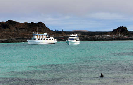 Two Yachts are anchored off shore in the Galapagos Islandsの写真素材