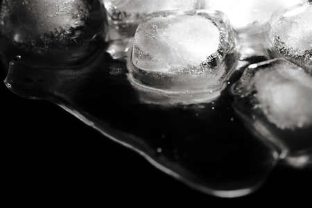Ice melting on a dark background. With blue lightの写真素材