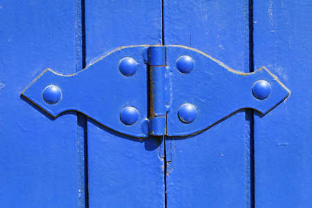 A brightly painted hinge on a wooden gateの写真素材
