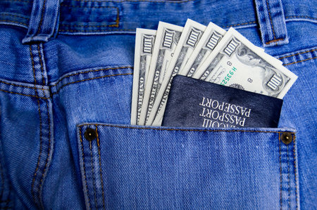 Passport with American dollars in the pocket of jeans