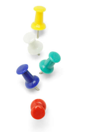 Elevated view of multicolor push pins arranged in a row on white backgroundの写真素材
