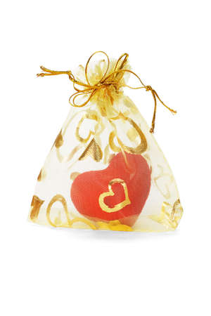 Red love heart ornament in gold sachet on white backgroundの写真素材