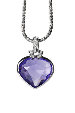 Silver pendant and blue heart shaped gemstone on white backgroundの写真素材