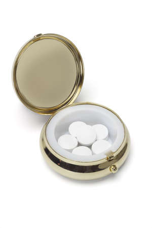 Medicine in round metal pill container on white backgroundの写真素材
