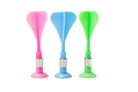 Multicolor plastic toy darts standing in a row on white backgroundの写真素材