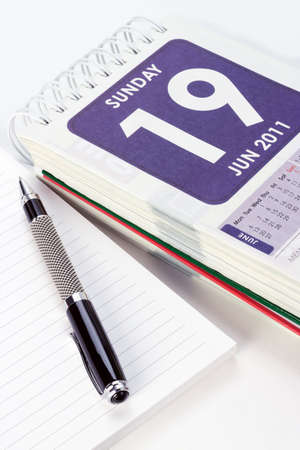 Pen and note book with calendar showing page on Father's day の写真素材