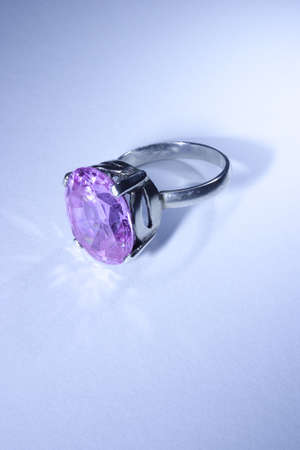 Jewelry ring with violet gemstone on blue backgroundの写真素材