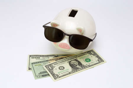 Conceptual image of piggy bank wearing sunglasses missing out on US dollarsの写真素材