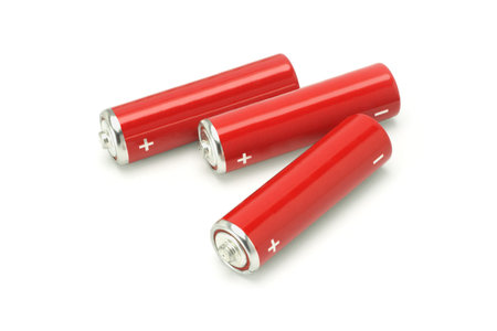 Three red AA size batteries on white backgroundの写真素材