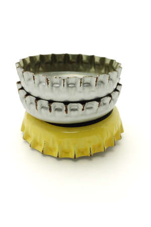 Stack of used bottle caps on white backgroundの写真素材