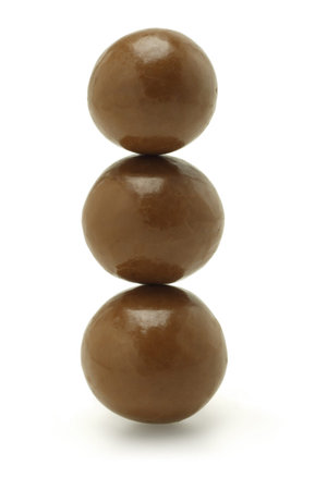 Stack of three chocolate balls on white backgroundの写真素材