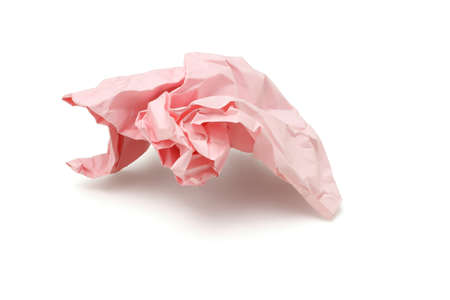 Crumbled pink colored paper discarded on white backgroundの写真素材