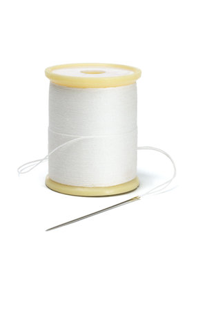 Needle and spool of thread on white background