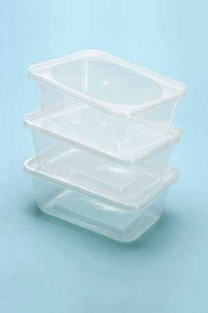 Stack of empty transparent plastic boxes on blue backgroundの写真素材