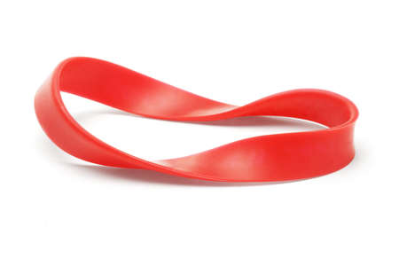 Twisted red rubber wrist band on white backgroundの写真素材