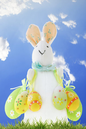 Easter bunny with decorative eggs against clear blue sky as background