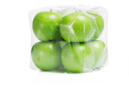 Fresh green apples in transparent packing on white backgroundの写真素材
