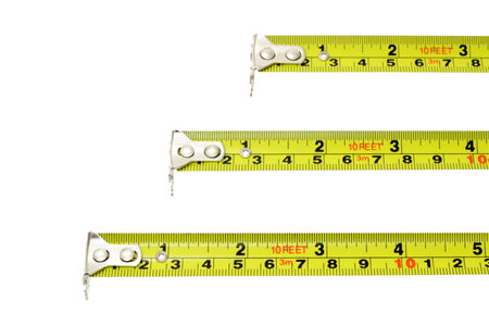 Measuring tapes of different lengths extended horizontally on white background with copy space