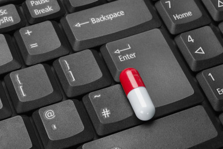 Red And White Capsule On Black Computer Keyboard