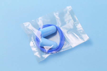 Ear Plugs in Sealed Plastic Bag on Blue Background