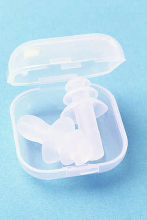 Pair of Ear Plugs in Open Plastic Container on Blue Backgroundの写真素材