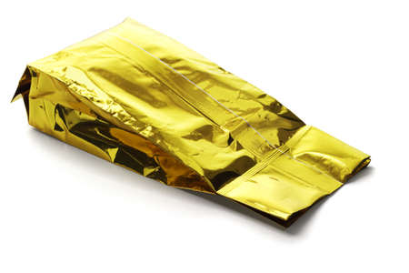 Golden Yellow Aluminum Pouch Lying on White Backgroundの写真素材