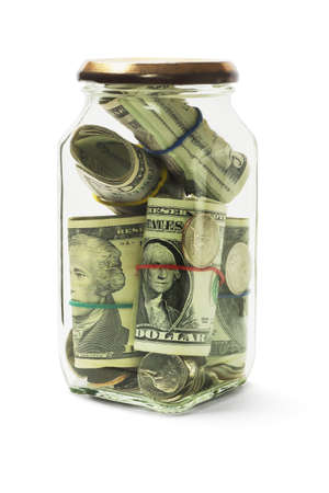 Rolled Up US Dollars Bills and Coins in Glass Jar on White Backgroundの写真素材