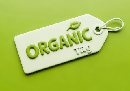 A white tag with embossed green text that reads ORGANIC and Tag, alongside a small green leaf symbol.の素材
