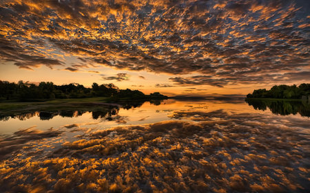 Beautiful sunset over the lake with clouds reflected in the water.の素材