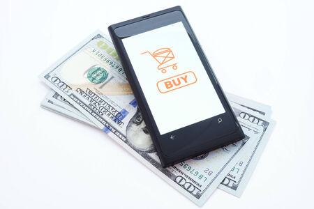 Smartphone with online shopping application on a screen and dollars  Isolated on white background の写真素材