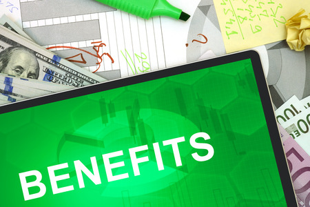 Tablet with words benefits with dollars and euro.の写真素材