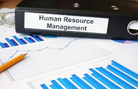 Graphs and file folder with label Human Resource Management.の写真素材