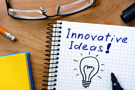 Notepad with innovative ideas on office wooden table.の写真素材